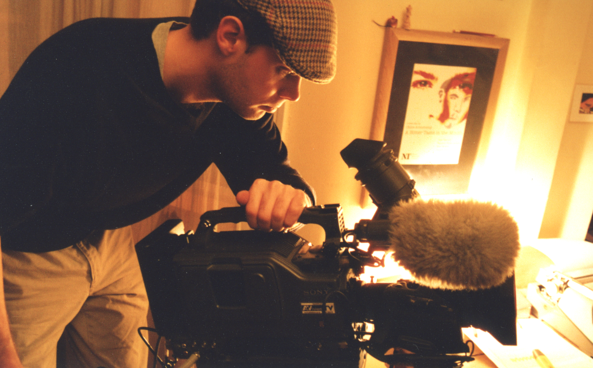 Tom Fogg standing over an old large digital video camera.